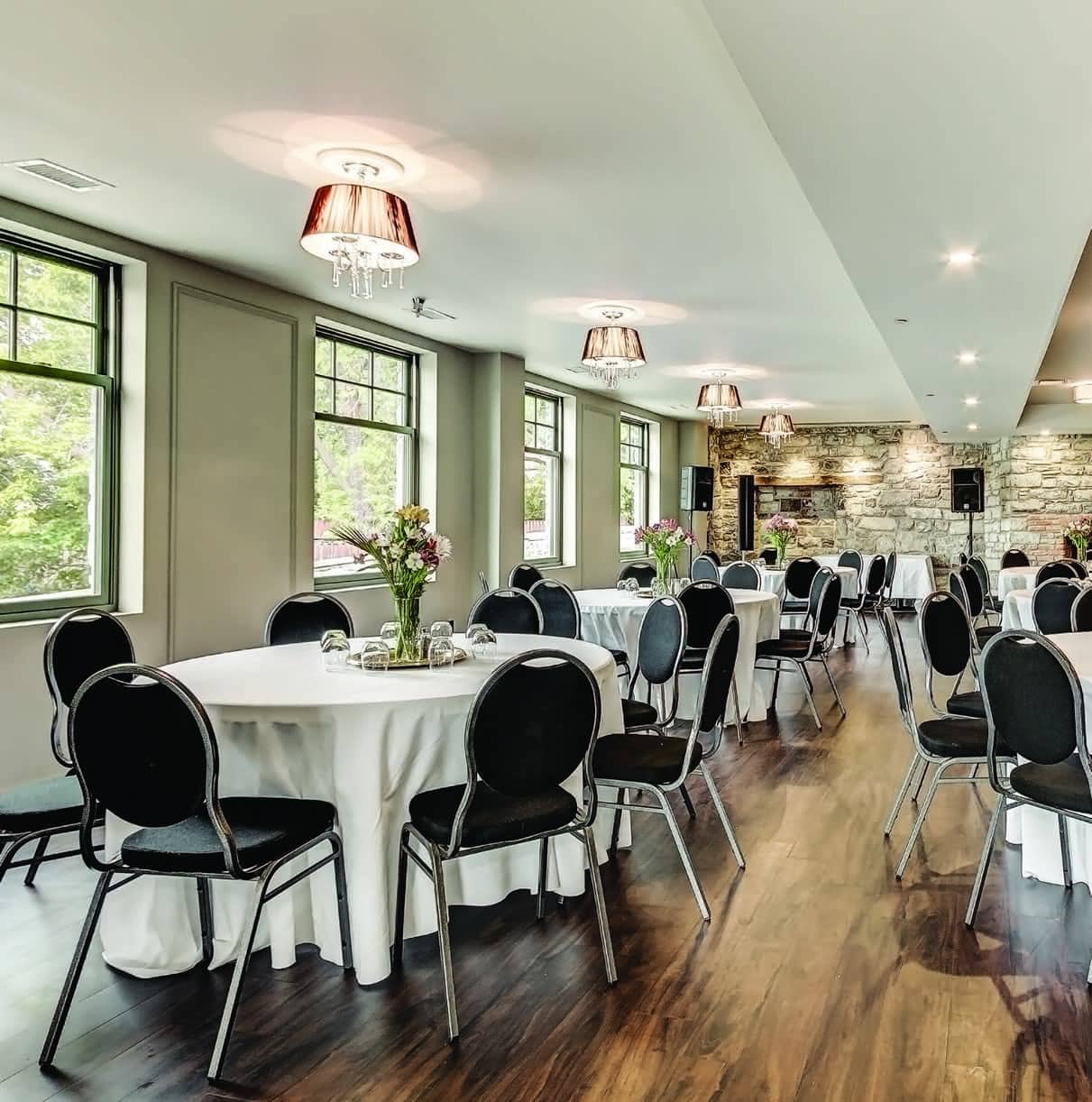 The Gold Room set with round tables, stone wall at the back