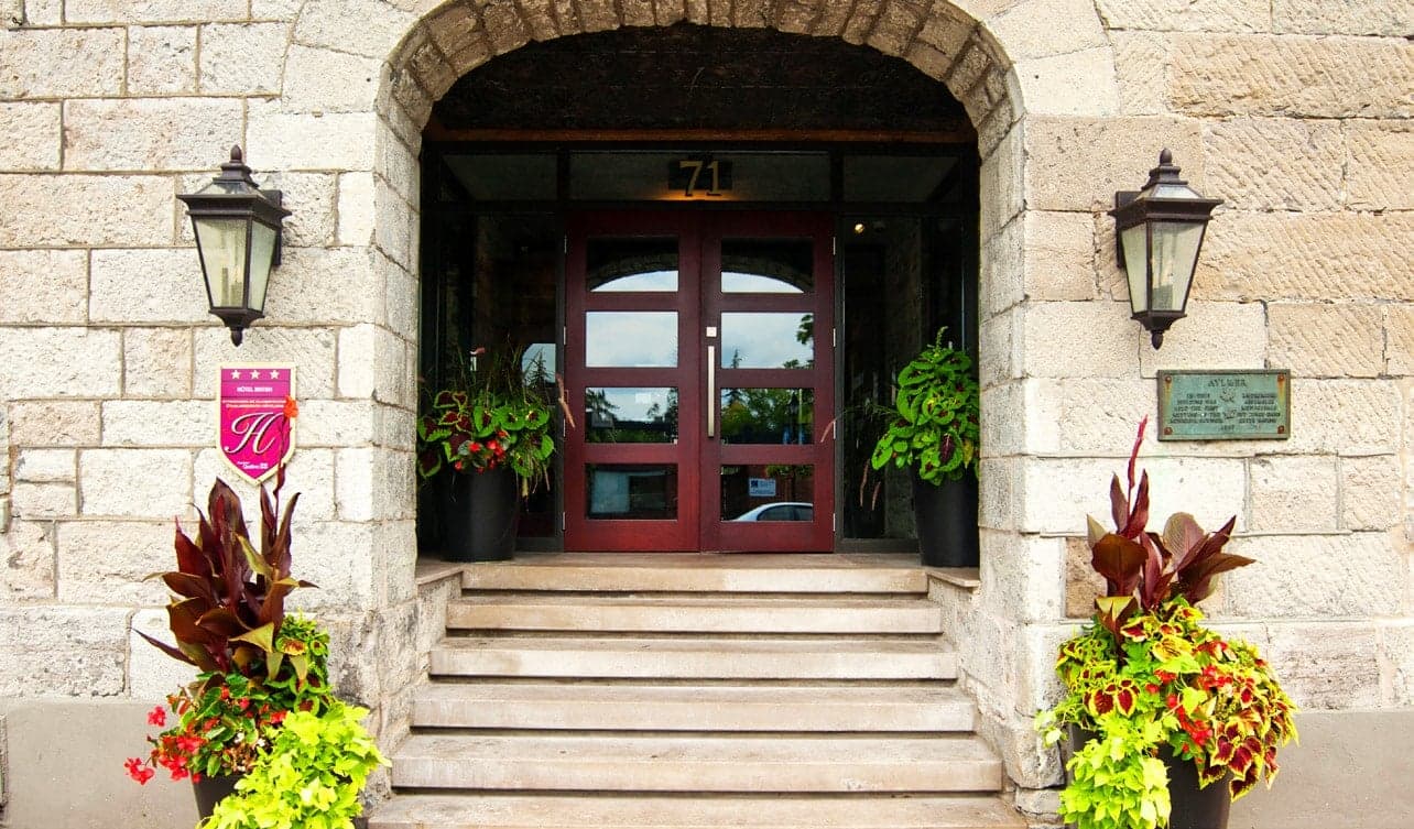 Stone steps up to the arched front door, with lanterns and flowers
